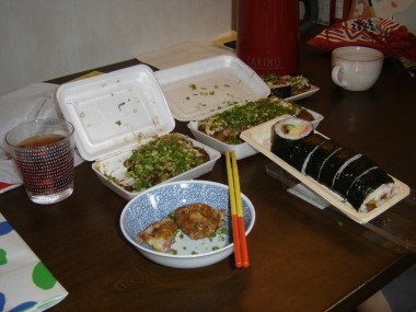 Some "tako yaki", fried octopus dumplings, covered in scallions. And futomaki sushi nori rolls.