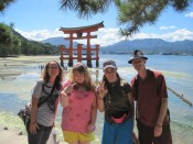 Standing in front of the famous huge Shinto torii gate of the Itsukushima Shrine on Miyajima Island in Hiroshima Bay, Japan. It's one of the most famous views in Japan.