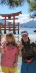 Standing in front of the famous huge Shinto torii gate of the Itsukushima Shrine on Miyajima Island in Hiroshima Bay, Japan. It’s one of the most famous views in Japan.
